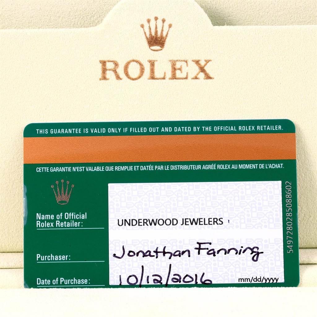 The image shows a close-up of the guarantee card and holder for a Rolex Daytona 116528 Men's Yellow Gold White Dial 116528 Men's Yellow Gold White Dial watch.