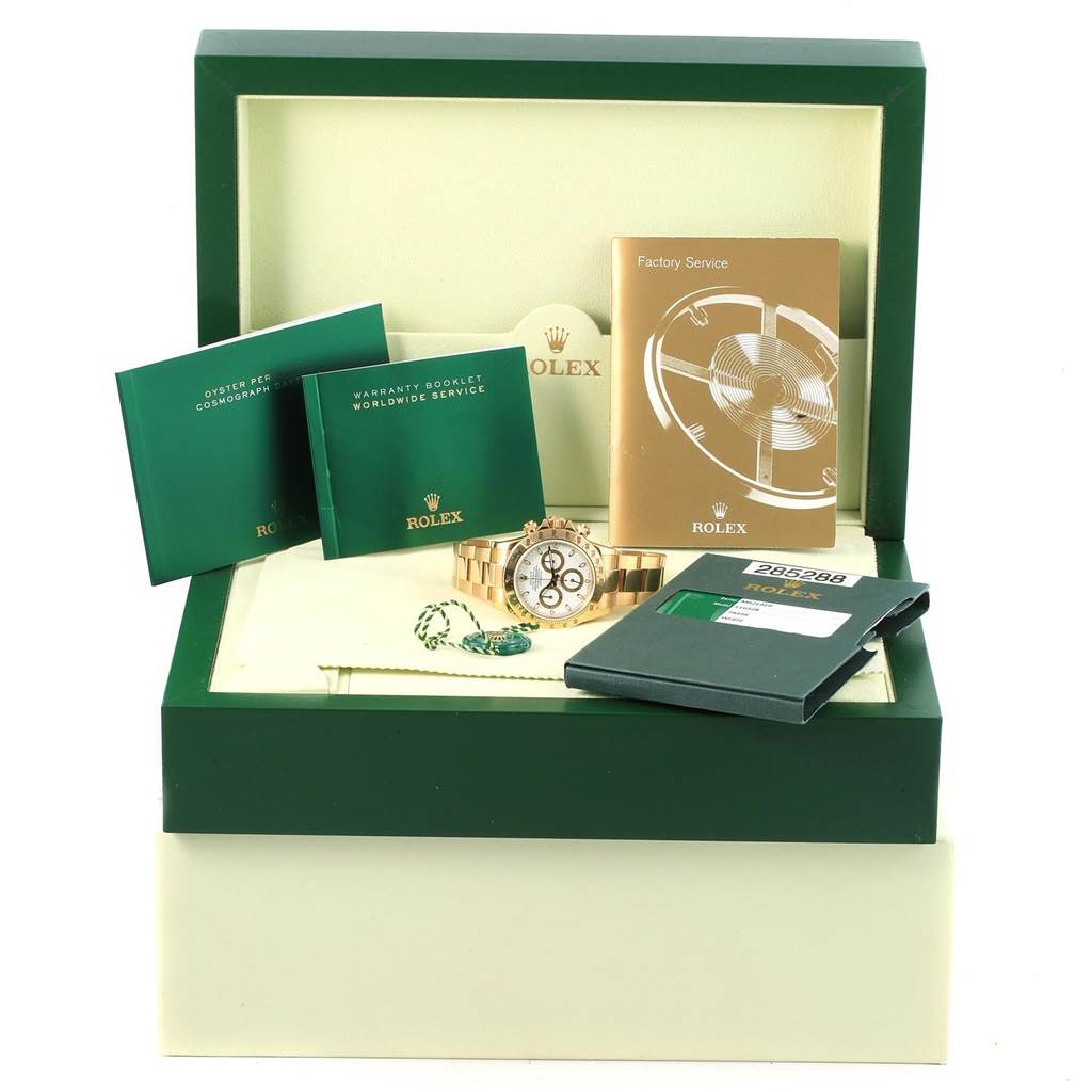 The image shows a Rolex Daytona 116528 Men's Yellow Gold White Dial 116528 Men's Yellow Gold White Dial watch in its box with booklets, a tag, and a warranty card.