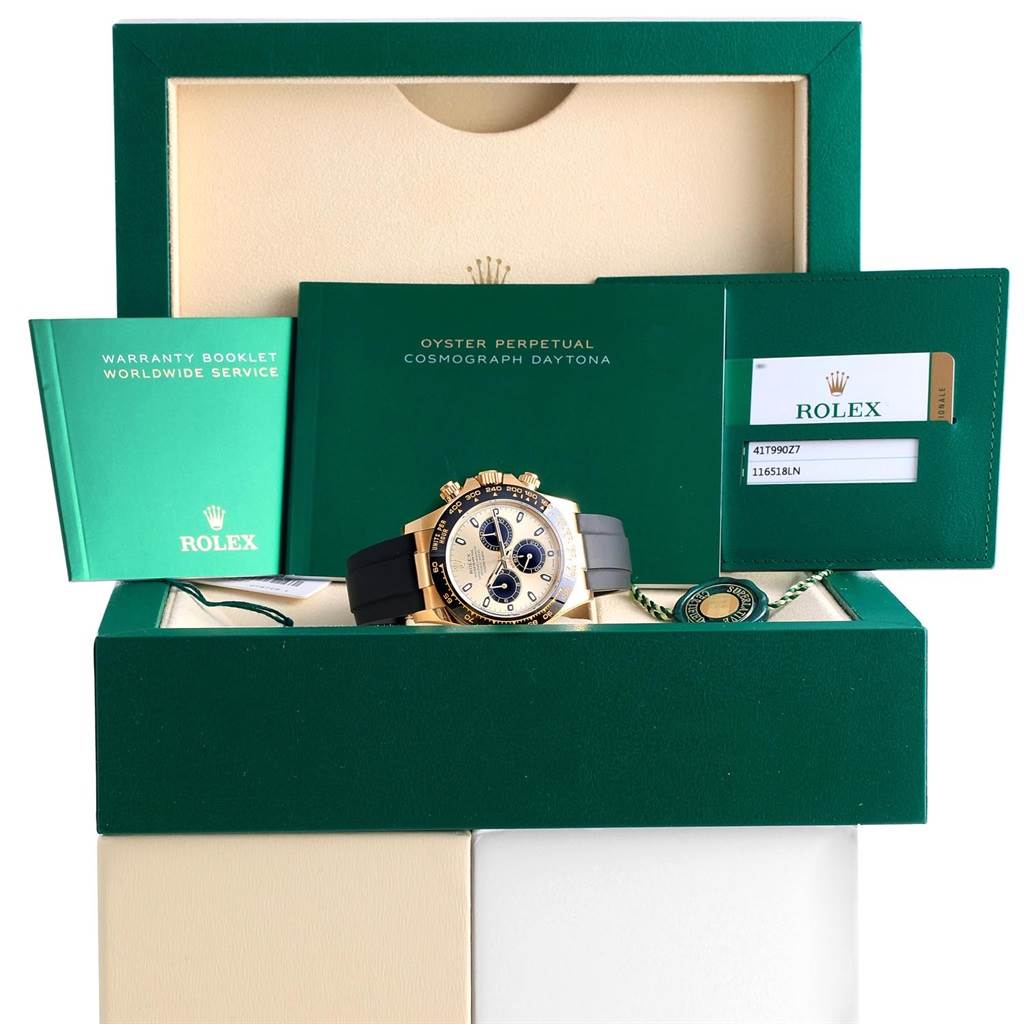 The image shows a front angle of a Rolex Daytona 116518 Men's Yellow Gold Champagne Dial 116518 Men's Yellow Gold Champagne Dial watch with its box, warranty booklet, and authenticity card.