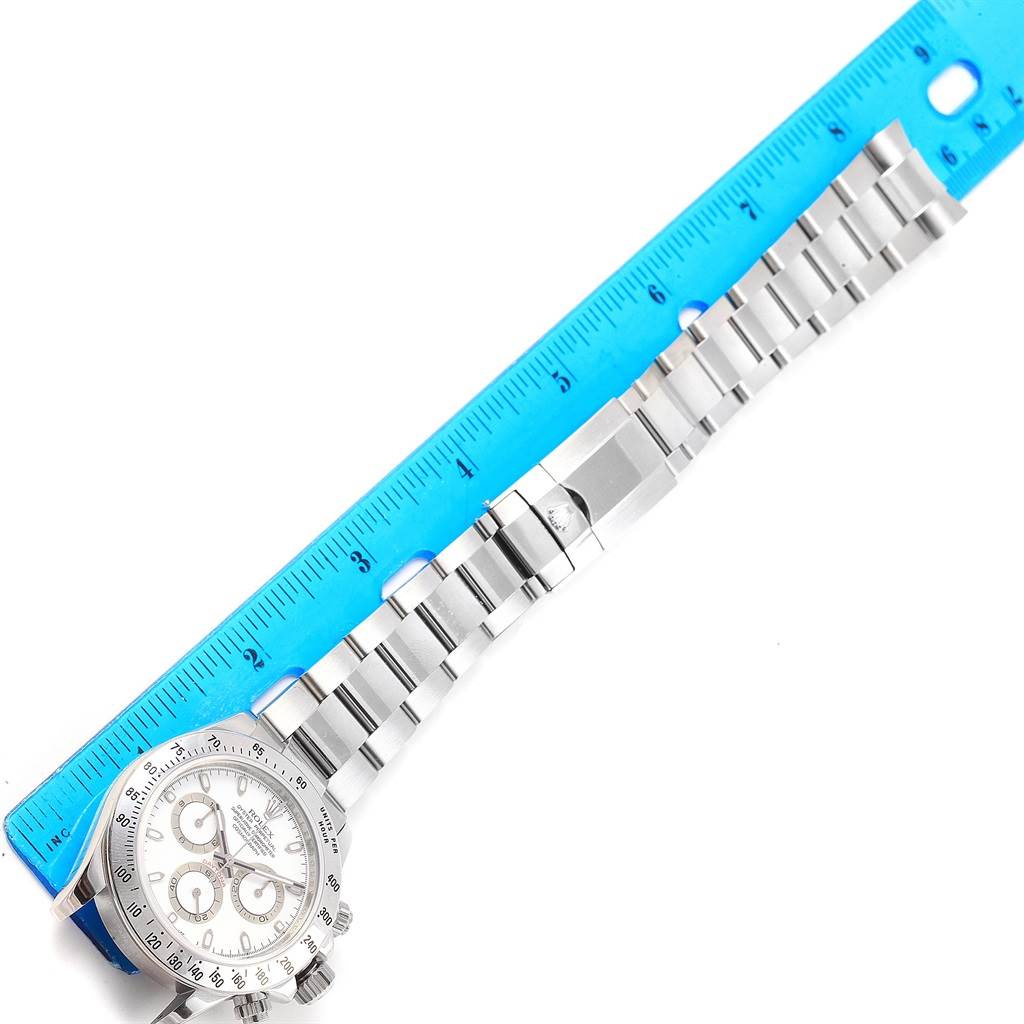 The image shows a Rolex Daytona 116520 Men's Stainless Steel White Dial 116520 Men's Stainless Steel White Dial watch laid flat and measured with a blue ruler, highlighting its bracelet and face.