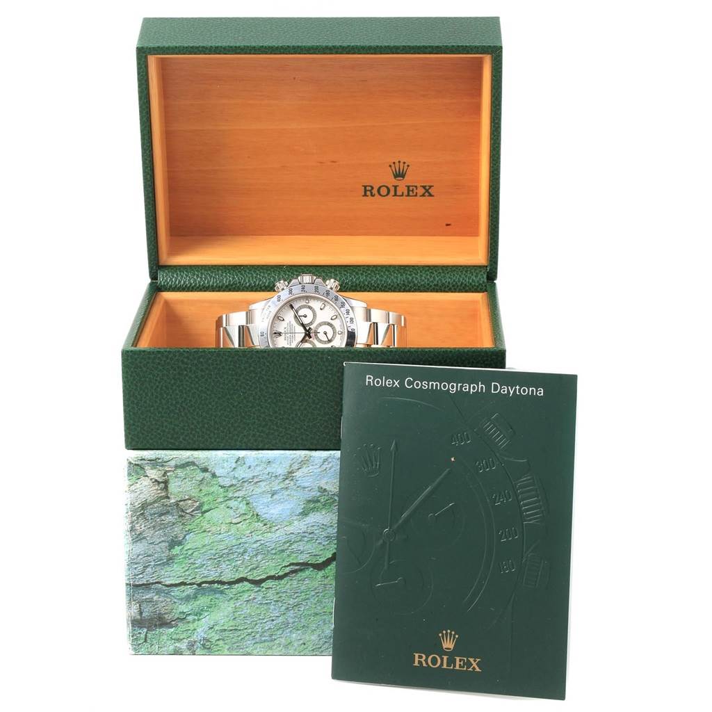 The image shows a Rolex Daytona 116520 Men's Stainless Steel White Dial 116520 Men's Stainless Steel White Dial watch in an open green Rolex box with its manual in front.