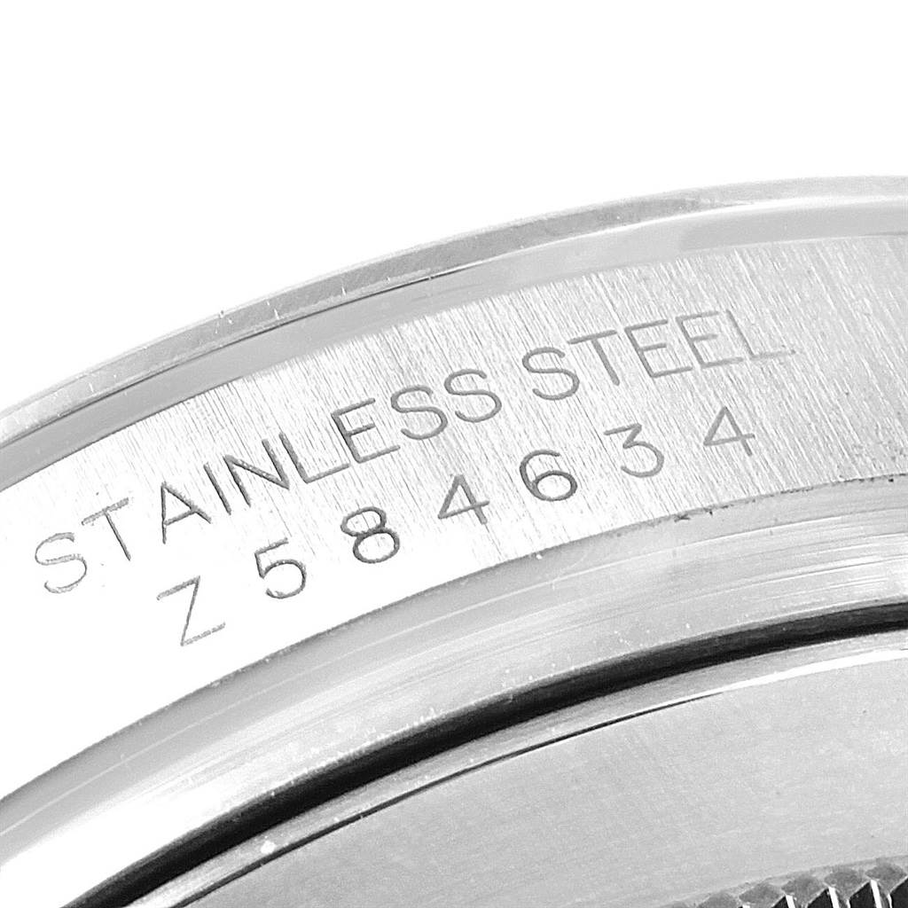 This image shows a close-up view of the engraving on the side of the case of a Rolex Daytona 116520 Men's Stainless Steel White Dial 116520 Men's Stainless Steel White Dial watch, highlighting the serial number and material.