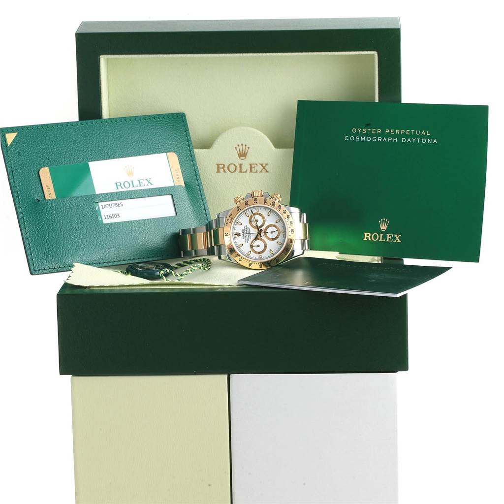 The Rolex Daytona 116503 Men's Steel and Gold (two tone) White Dial 116503 Men's Steel and Gold (two tone) White Dial watch is shown with its box, certificate, and booklets, angled slightly from the front.