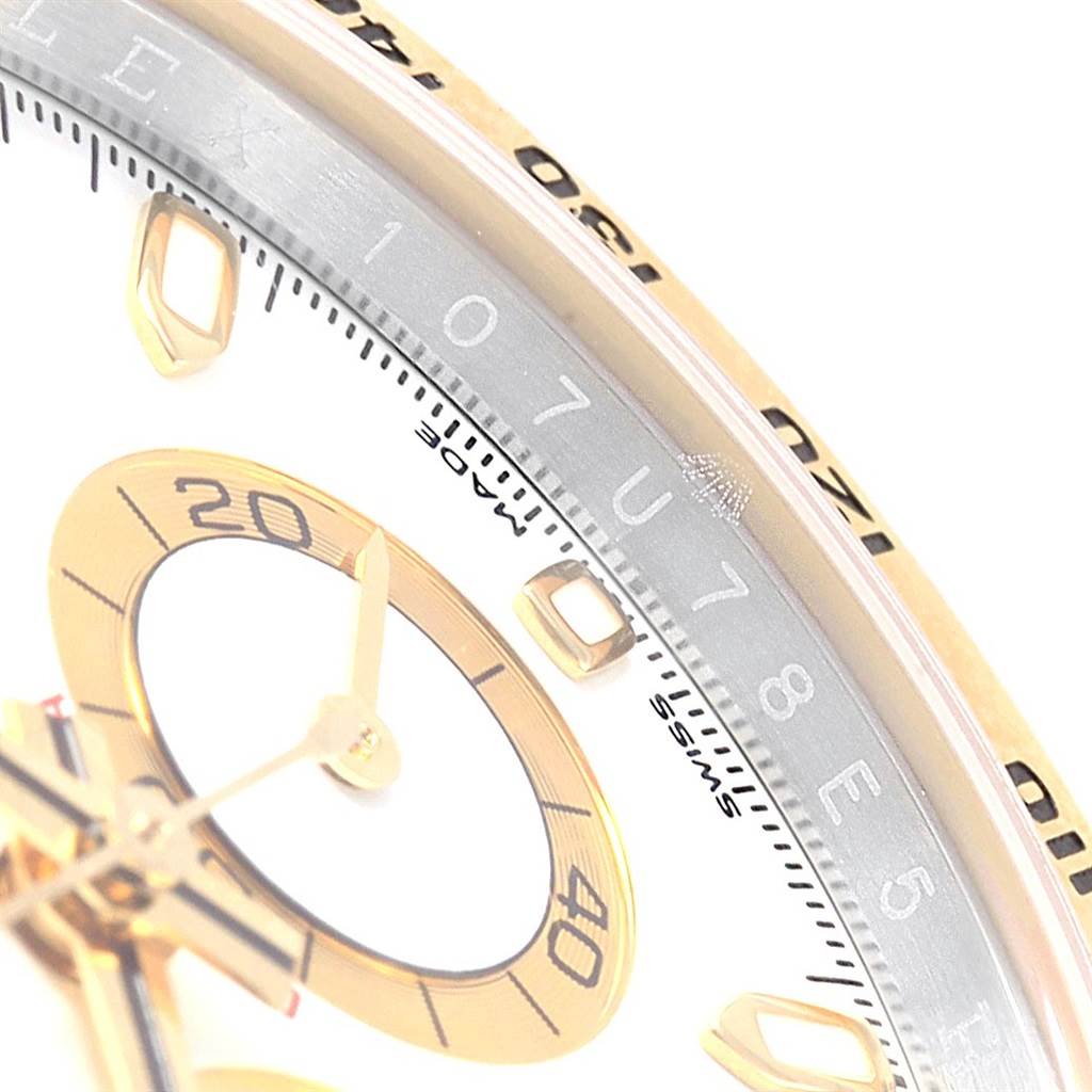 This close-up shot of the Rolex Daytona 116503 Men's Steel and Gold (two tone) White Dial 116503 Men's Steel and Gold (two tone) White Dial watch shows part of the dial, hands, and markers, along with a portion of the bezel and outer edge.