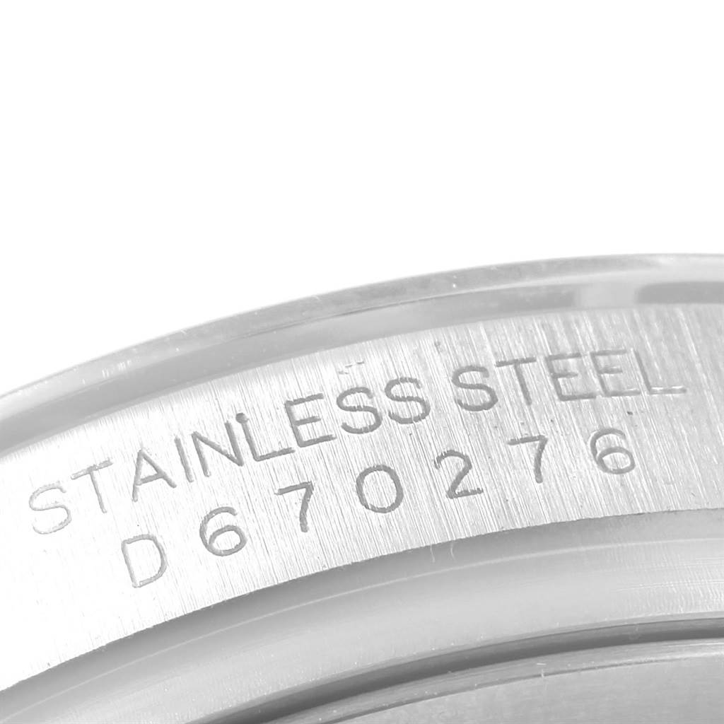 Close-up of the Rolex Daytona 116520 Men's Stainless Steel White Dial 116520 Men's Stainless Steel White Dial showing the engraved serial number and "STAINLESS STEEL" inscription on the case.