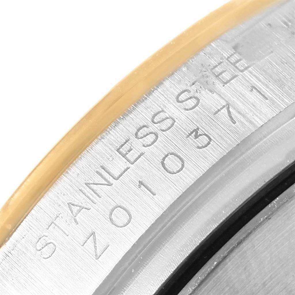This close-up image shows the serial number engraving on the side of the case of a Rolex Daytona 116523 Men's Steel and Gold (two tone) Black Dial 116523 Men's Steel and Gold (two tone) Black Dial watch.