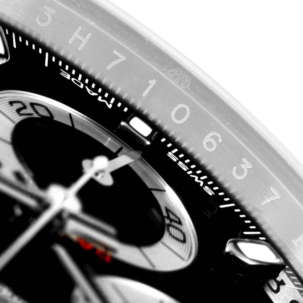 The image shows a close-up of the dial and bezel of a Rolex Daytona 116500 Men's Stainless Steel Black Dial 116500 Men's Stainless Steel Black Dial watch, highlighting numbers and part of the chronograph.