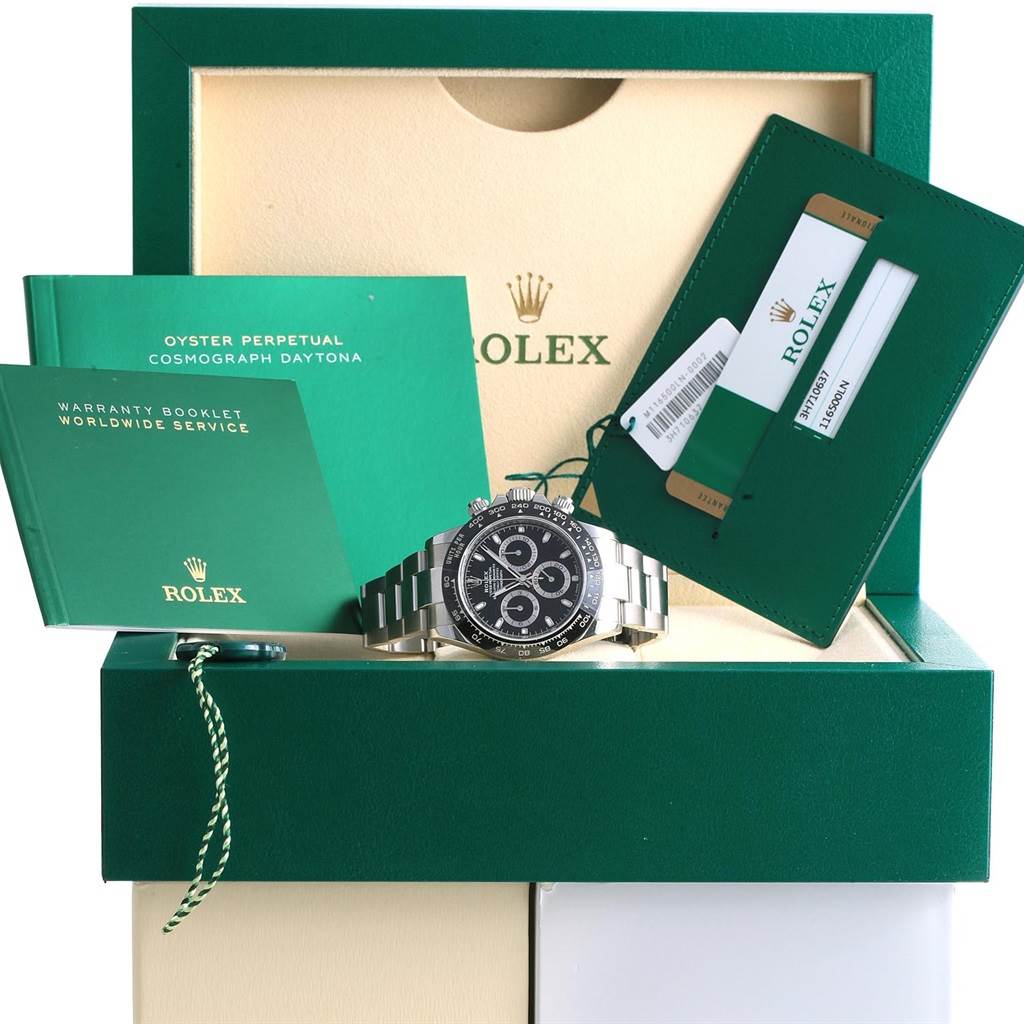 The Rolex Daytona 116500 Men's Stainless Steel Black Dial 116500 Men's Stainless Steel Black Dial watch is displayed front-facing with its packaging, manuals, warranty booklet, and cardholder.