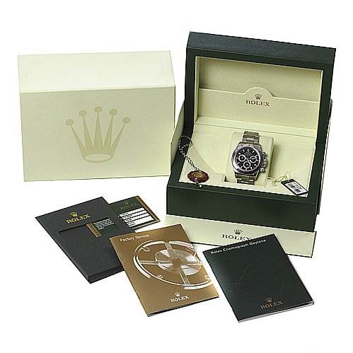 The image shows a Rolex Daytona 116520 Men's Stainless Steel Black Dial 116520 Men's Stainless Steel Black Dial watch in its box, accompanied by manuals, warranty cards, and the outer packaging.