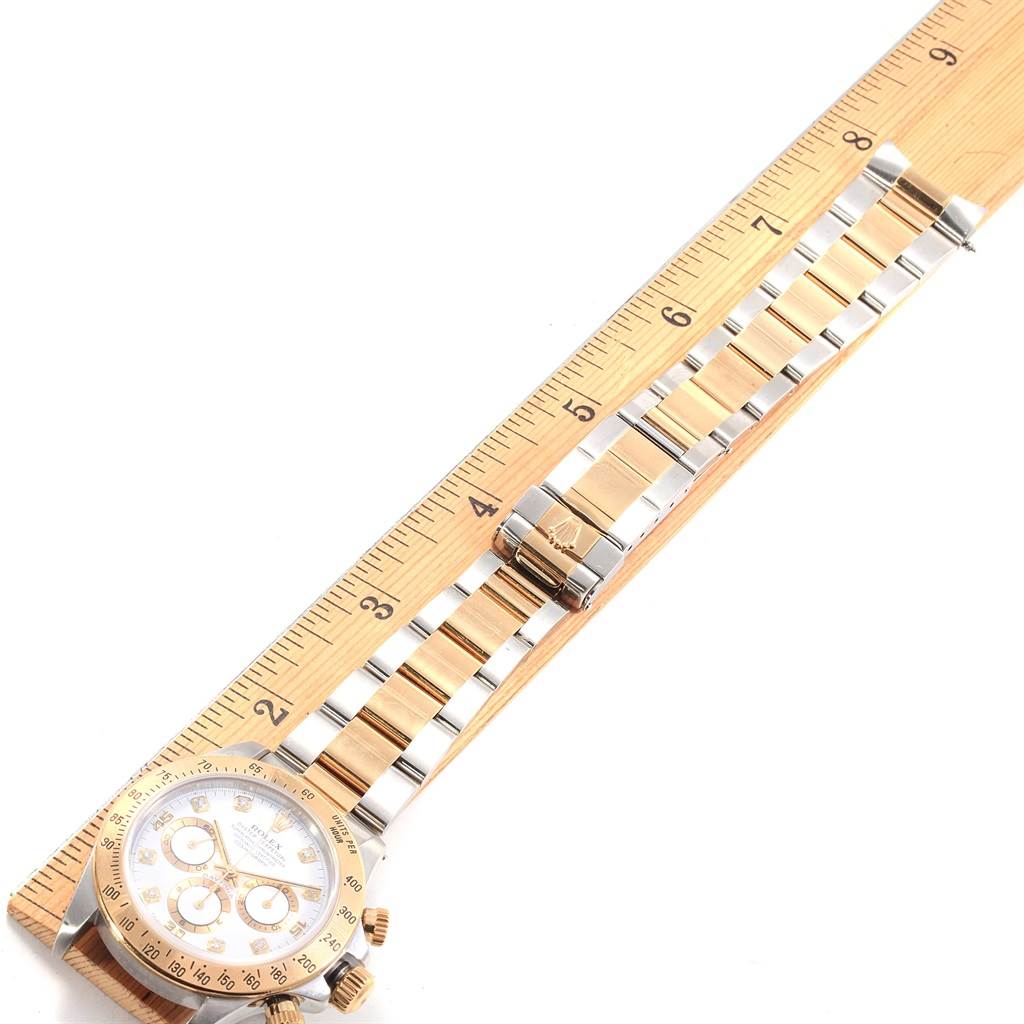 A Rolex Daytona 16523 Men's Steel and Gold (two tone) White Dial 16523 Men's Steel and Gold (two tone) White Dial watch is shown flat on a ruler, displaying the face and entire band.