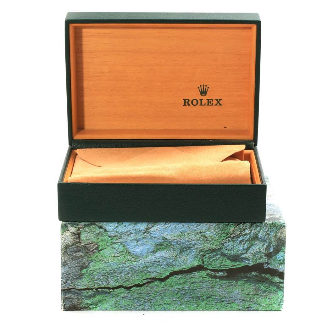 The image shows an open Rolex watch box, likely for a Daytona model, displaying the interior cushion and lid with branding.