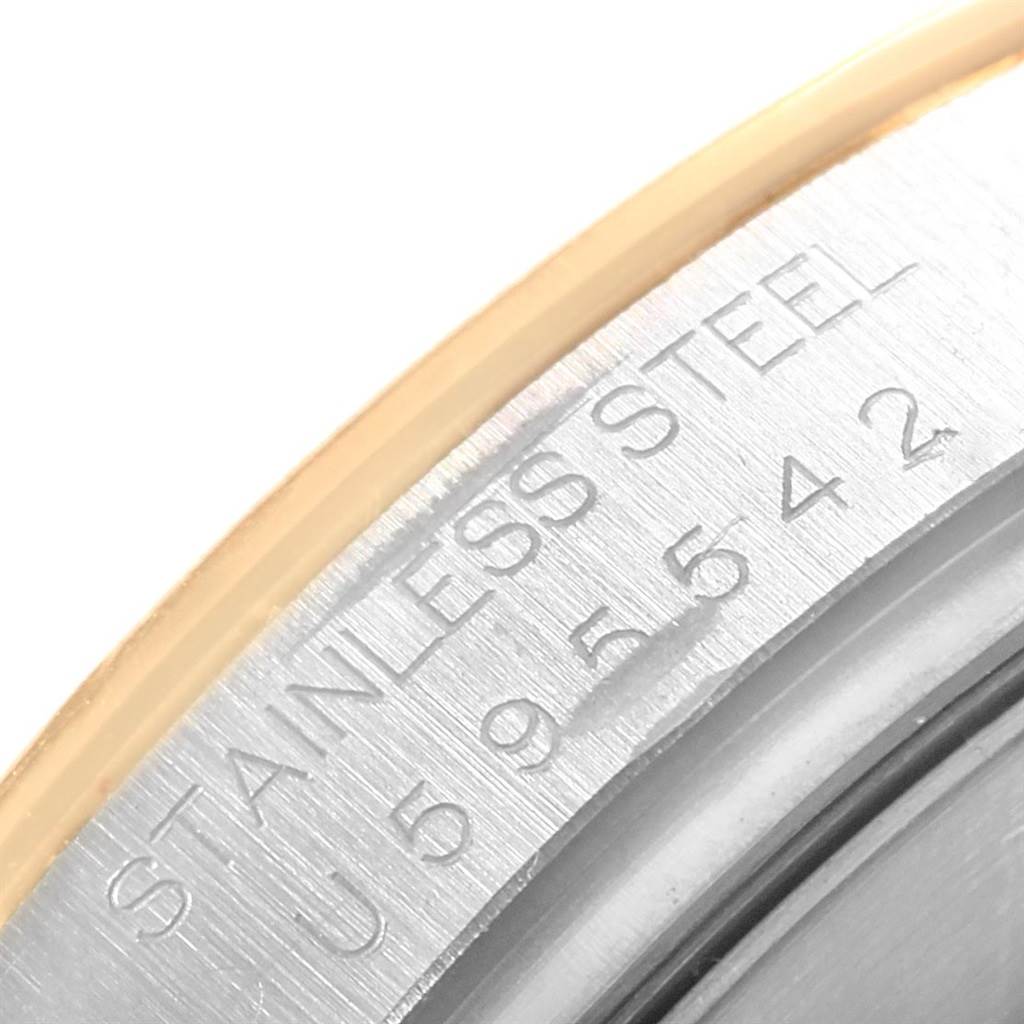 The image shows a close-up of the edge of a Rolex Daytona 16523 Men's Steel and Gold (two tone) White Dial 16523 Men's Steel and Gold (two tone) White Dial watch's case, highlighting the "STAINLESS STEEL" engraving.