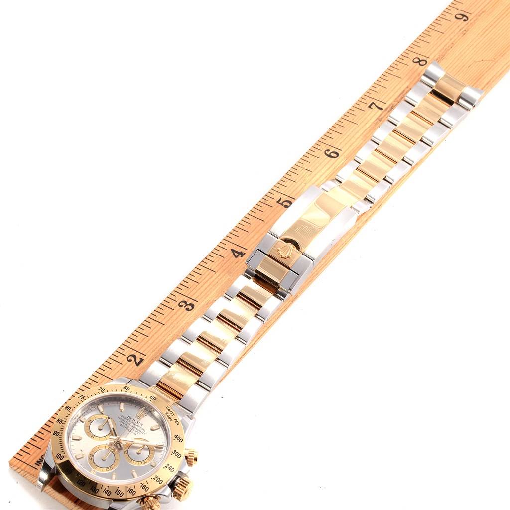 The Rolex Daytona 116523 Men's Steel and Gold (two tone) Grey Dial 116523 Men's Steel and Gold (two tone) Grey Dial watch is shown from a top-down angle, including the face and entire bracelet laid against a ruler.