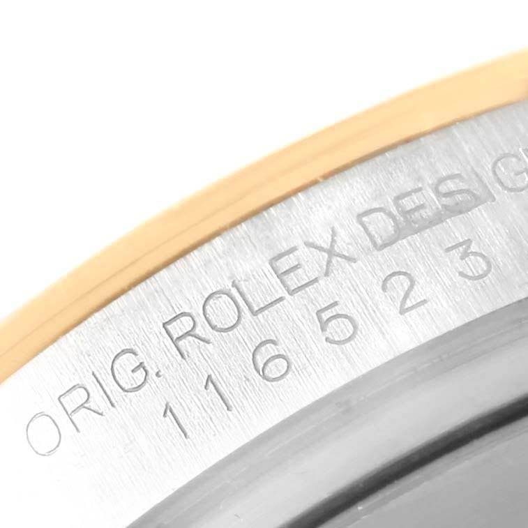 This image shows a close-up of the serial number engraved on the bezel of a Rolex Daytona 116523 Men's Steel and Gold (two tone) Grey Dial 116523 Men's Steel and Gold (two tone) Grey Dial watch.