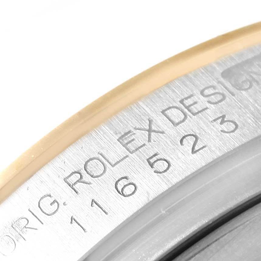The image shows a close-up view of the engravings on the bezel of a Rolex Daytona 116523 Men
s Steel and Gold (two tone) Mother of Pearl Dial 116523 Men
s Steel and Gold (two tone) Mother of Pearl Dial watch, highlighting the model number and branding.