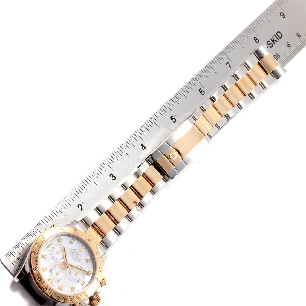 This image shows a Rolex Daytona 116523 Men
s Steel and Gold (two tone) Mother of Pearl Dial 116523 Men
s Steel and Gold (two tone) Mother of Pearl Dial watch laid flat, measured against a ruler, highlighting the face and bracelet.