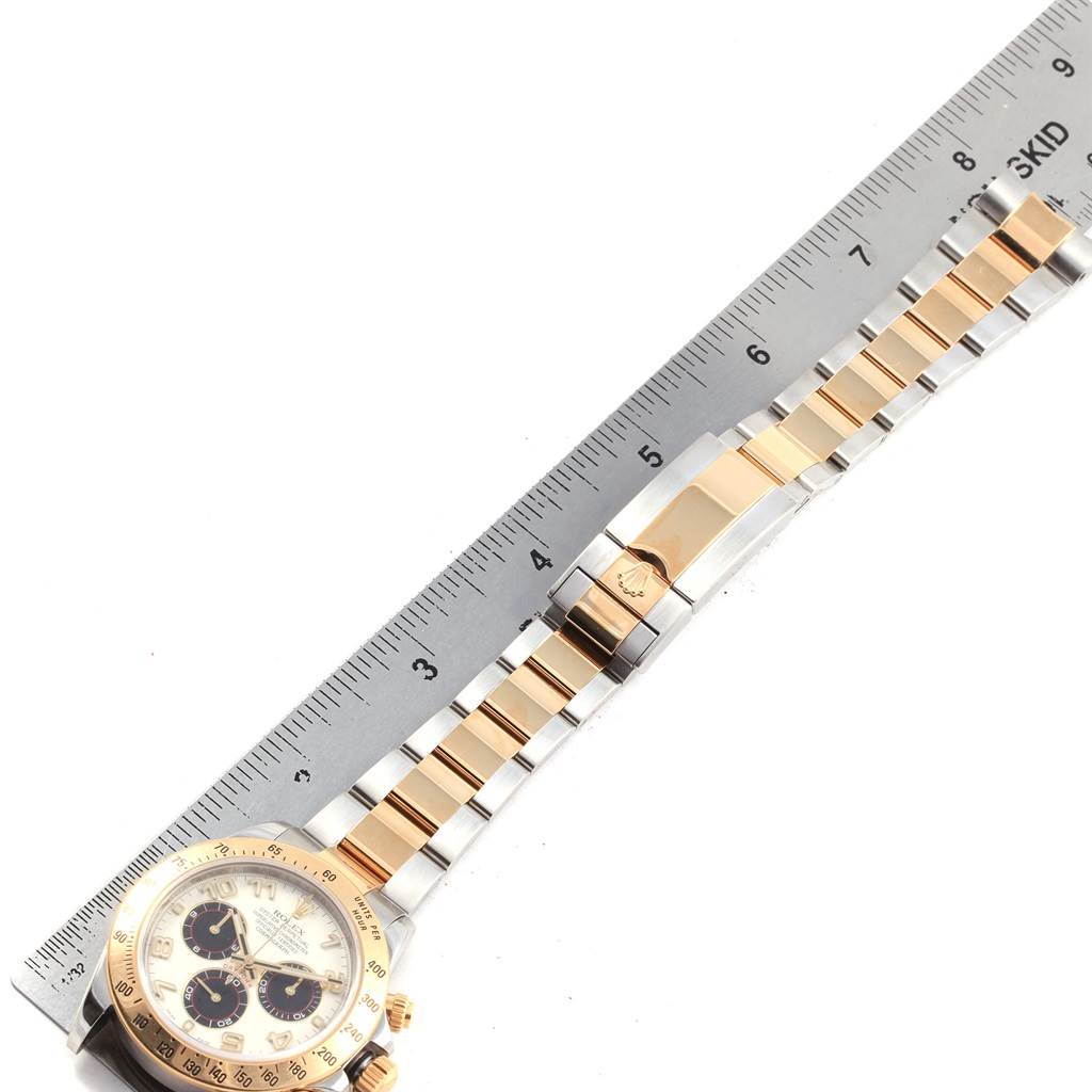 The image shows a Rolex Daytona 116523 Men's Steel and Gold (two tone) White Dial 116523 Men's Steel and Gold (two tone) White Dial watch laid flat with a metal and gold bracelet, alongside a ruler.