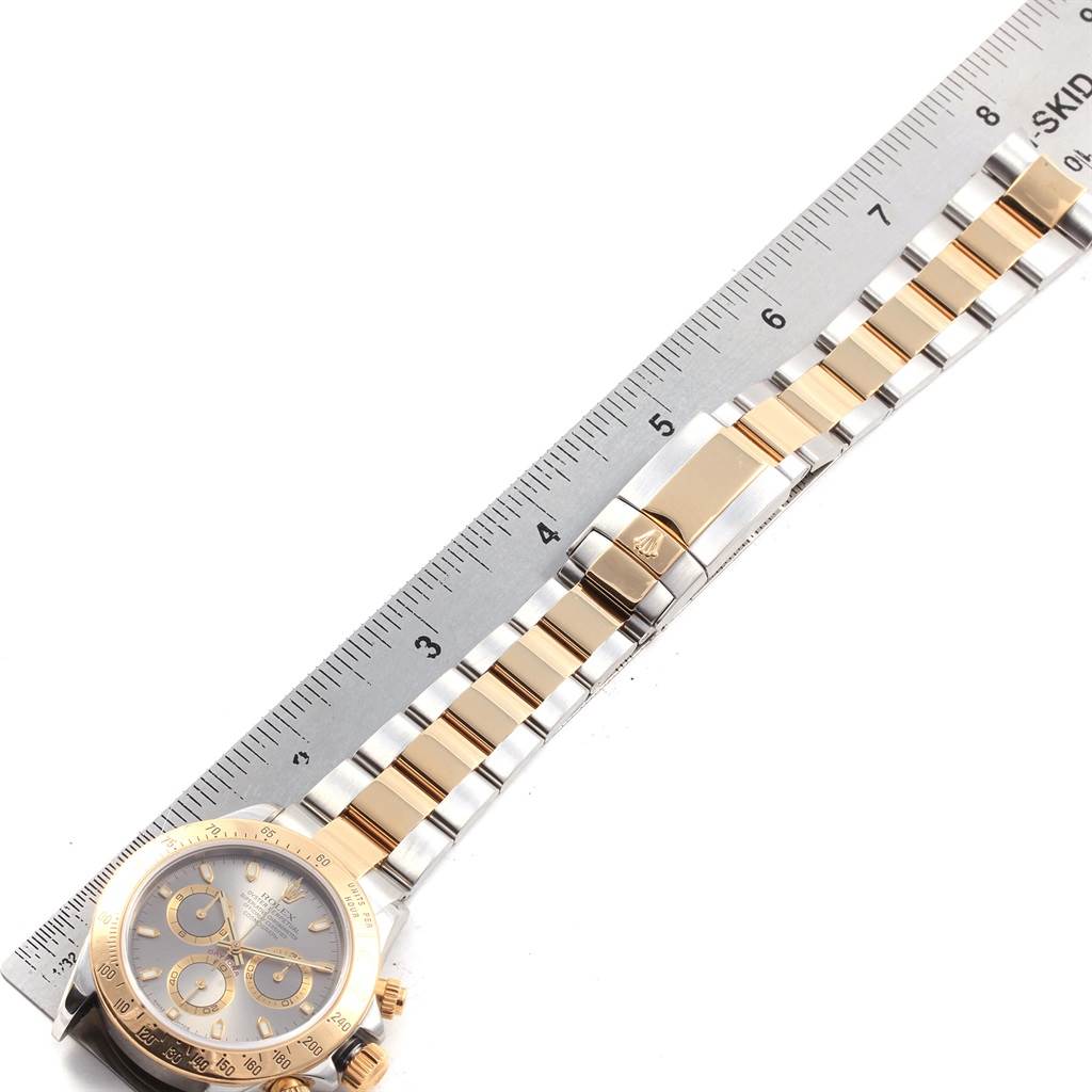 The image shows a Rolex Daytona 116523 Men's Steel and Gold (two tone) Grey Dial 116523 Men's Steel and Gold (two tone) Grey Dial watch laid flat with a focus on its bracelet and clasp.