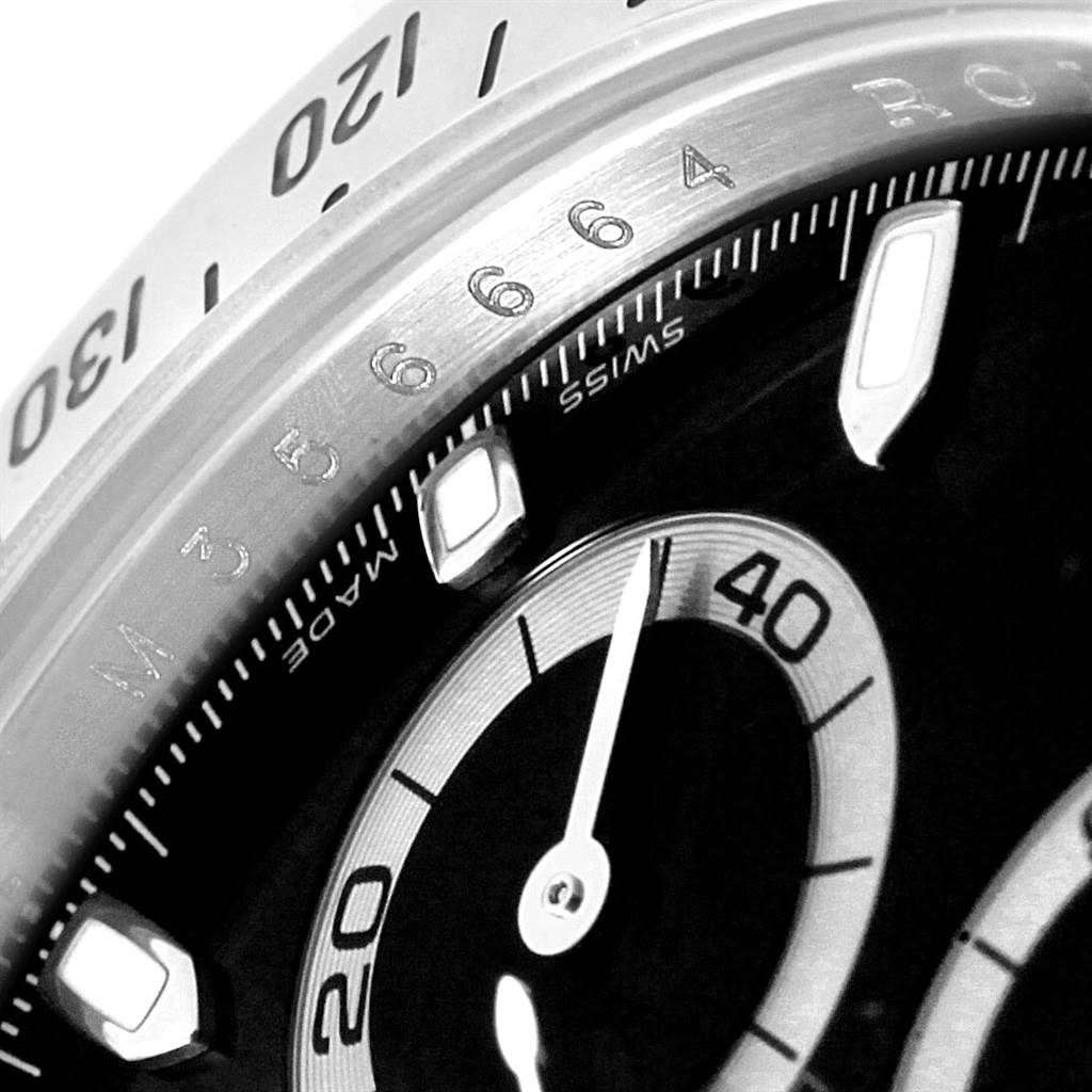The image shows a close-up of the dial and bezel of a Rolex Daytona 116520 Men's Stainless Steel Black Dial 116520 Men's Stainless Steel Black Dial watch, highlighting the numerical markers and part of the chronograph.