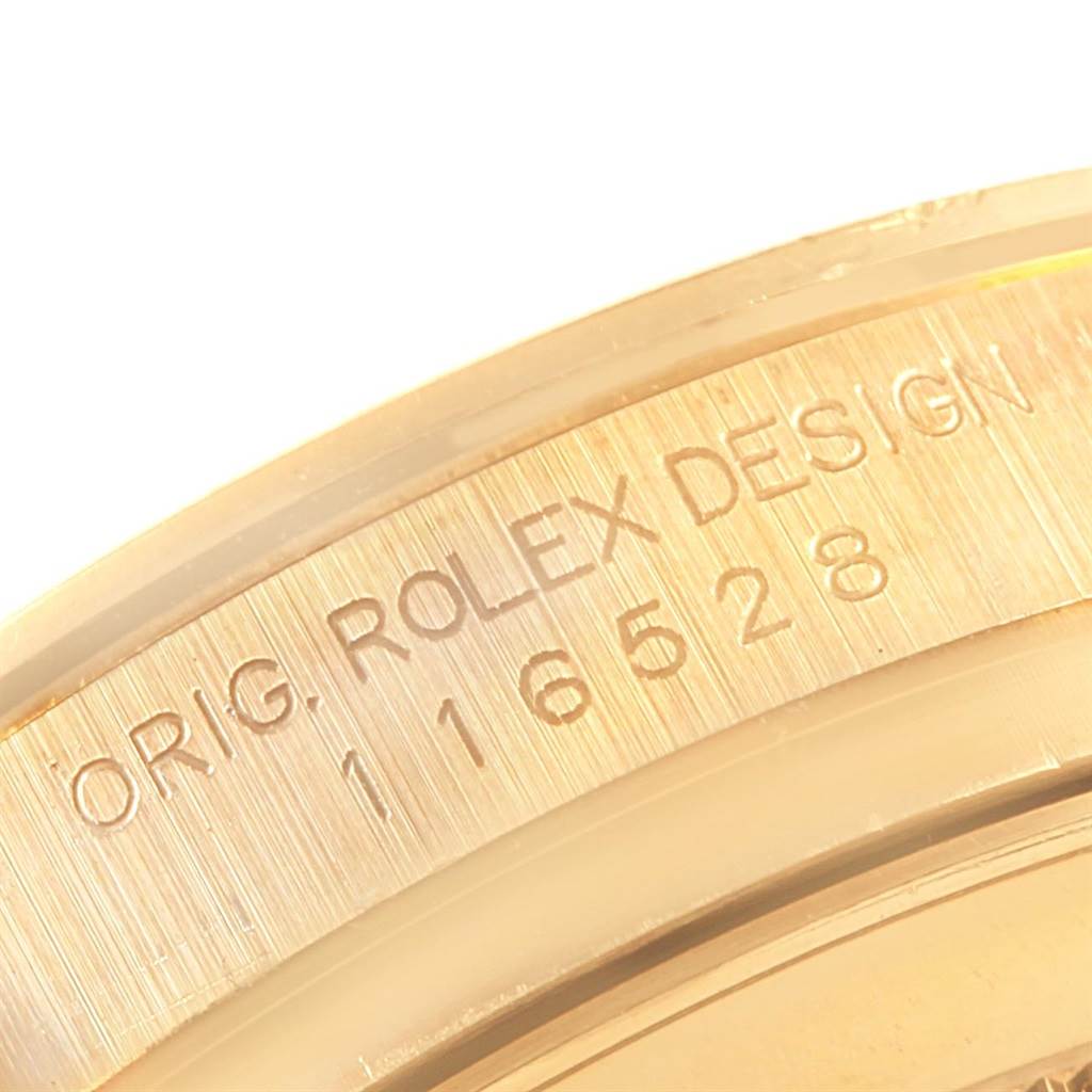 The image shows a close-up of the inscription on the case of a Rolex Daytona 116528 Men's Yellow Gold Champagne Dial 116528 Men's Yellow Gold Champagne Dial watch.