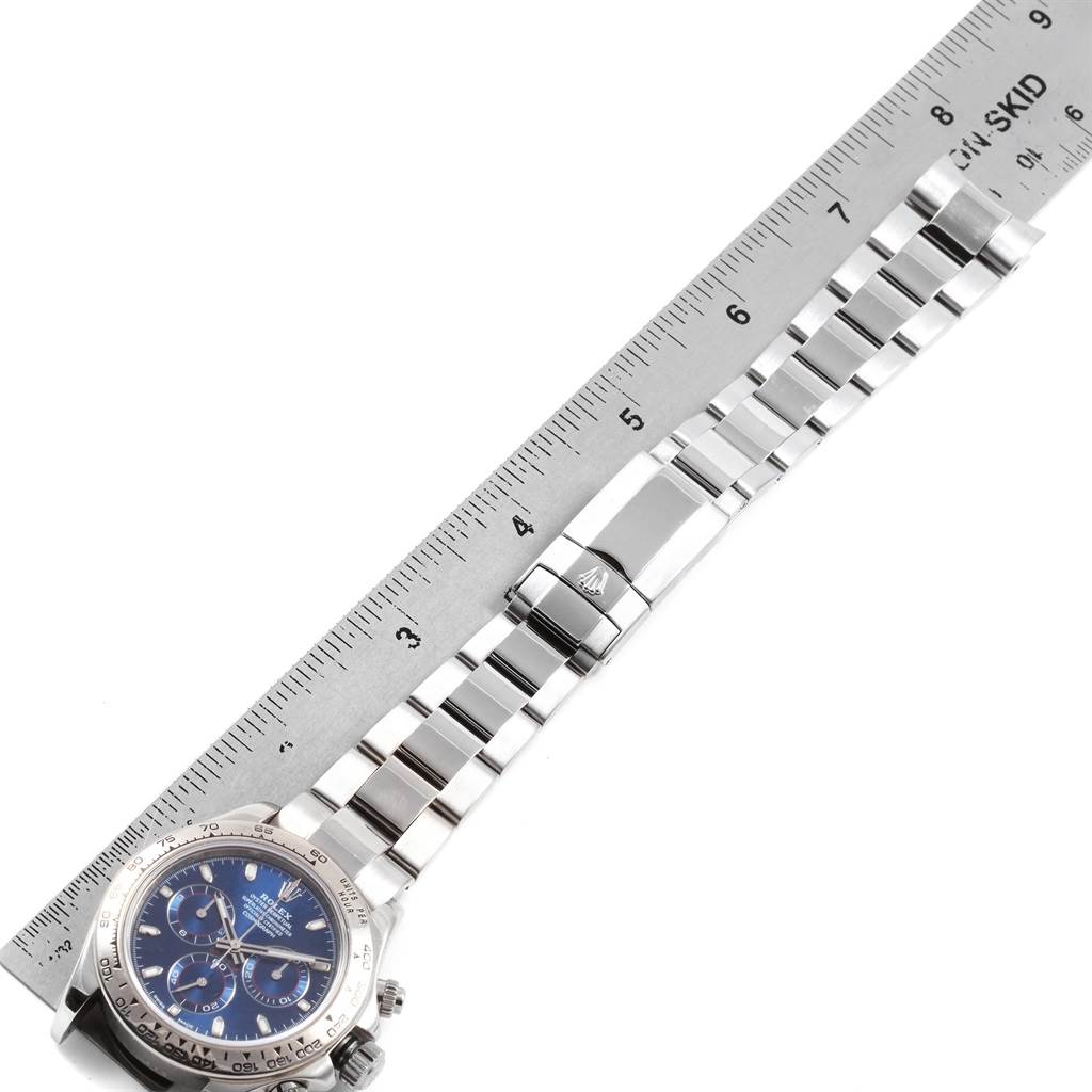 The image shows a Rolex Daytona 116509 Men's White Gold Blue Dial 116509 Men's White Gold Blue Dial watch laid next to a ruler, focusing on its bracelet and clasp.