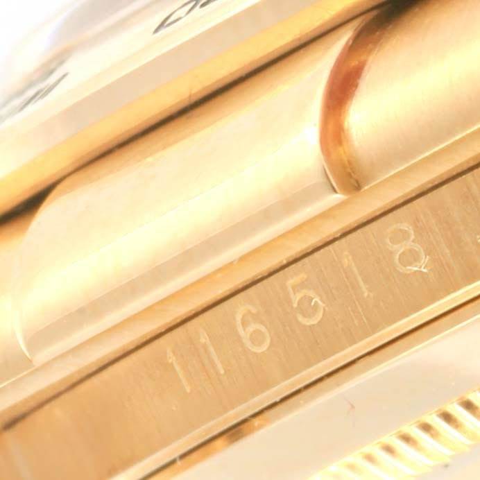 This close-up image of the Rolex Daytona 116518 Men's Yellow Gold Black Dial 116518 Men's Yellow Gold Black Dial watch shows the side view with an engraved model number "116518."