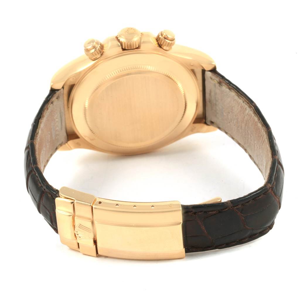 The image shows the back of the Rolex Daytona 116518 Men's Yellow Gold Black Dial 116518 Men's Yellow Gold Black Dial watch case and clasp, highlighting the gold casing and leather strap.