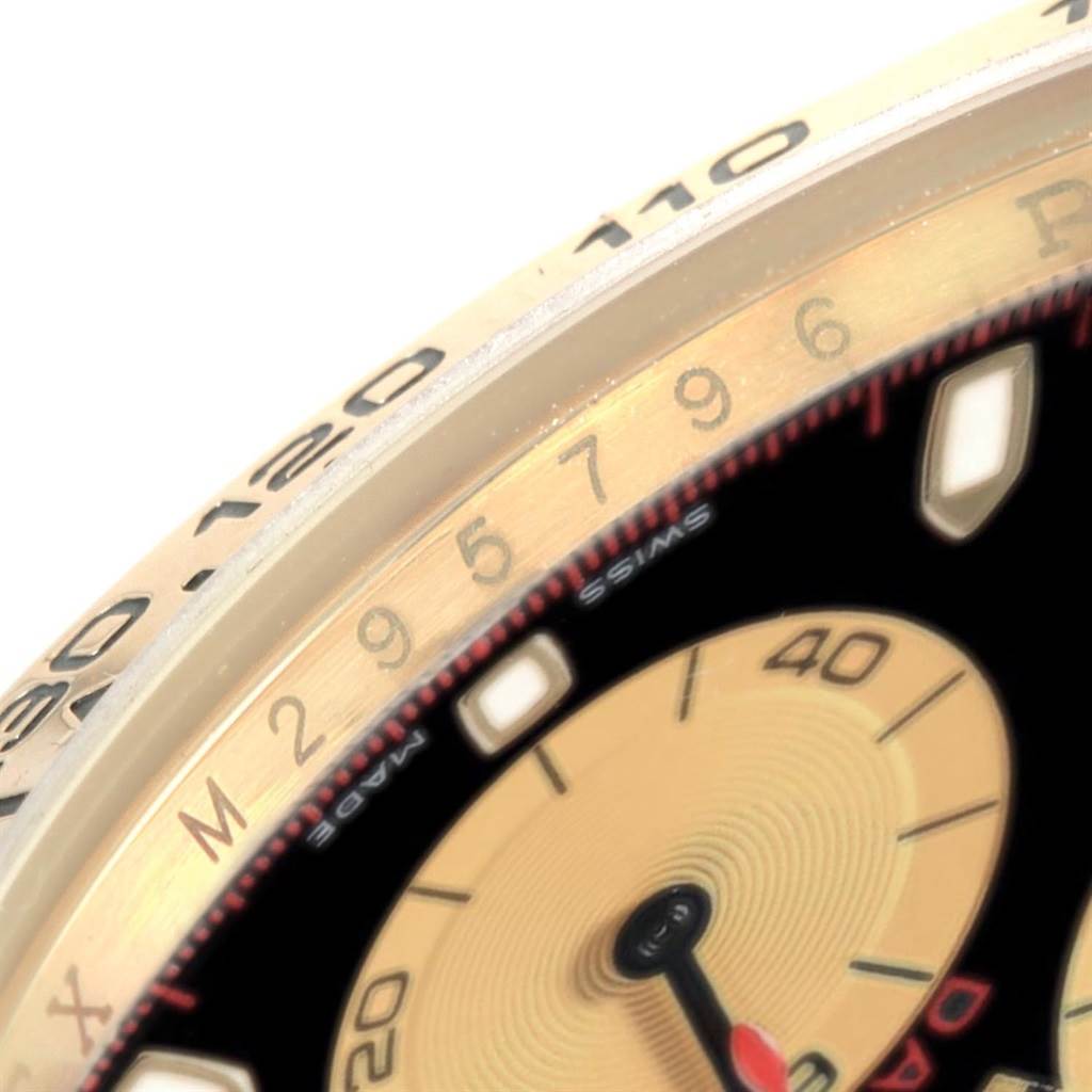 This close-up angle of the Rolex Daytona 116518 Men's Yellow Gold Black Dial 116518 Men's Yellow Gold Black Dial watch shows part of the bezel, dial, and a subdial.