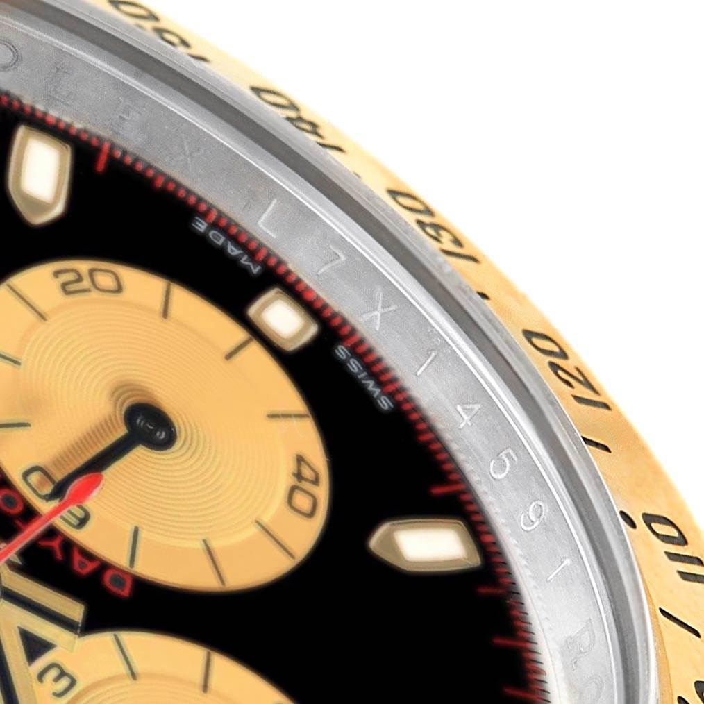 This close-up image of the Rolex Daytona 116523 Men's Steel and Gold (two tone) Black Dial 116523 Men's Steel and Gold (two tone) Black Dial watch shows part of the dial, sub-dials, and the outer edge of the bezel.