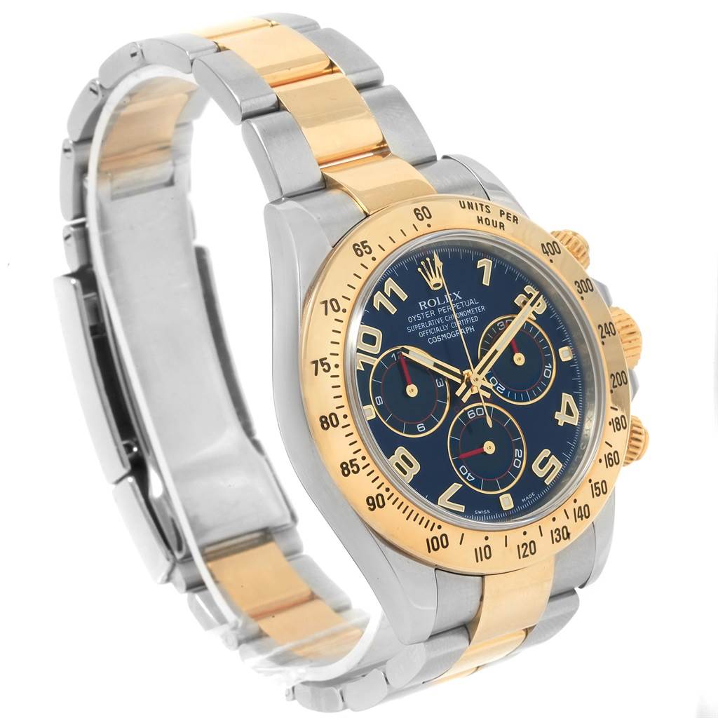 The image shows a side angled view of a Rolex Daytona 116523 Men's Steel and Gold (two tone) Blue Dial 116523 Men's Steel and Gold (two tone) Blue Dial watch with a gold and stainless steel bracelet and a black dial.