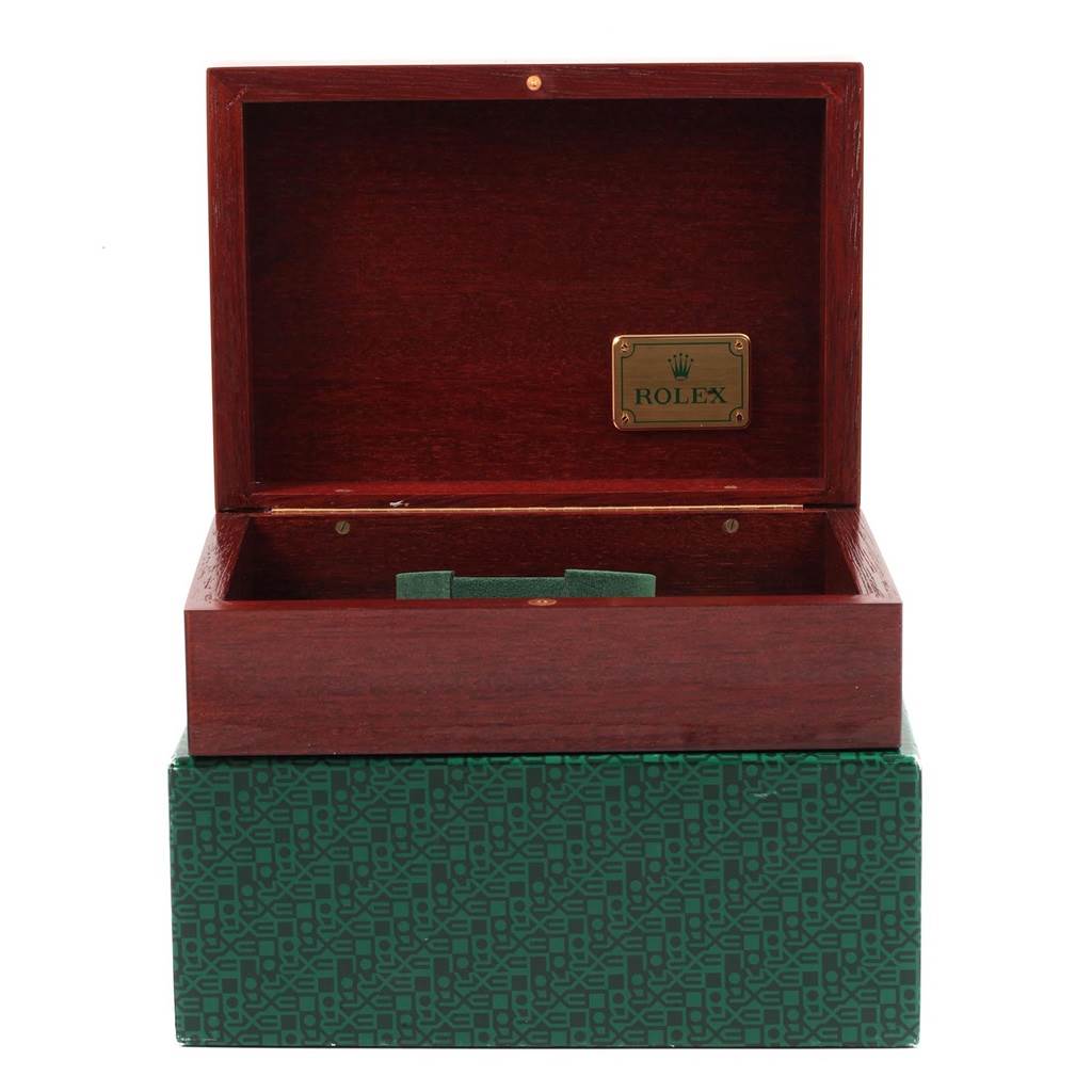 The image shows an open Rolex box for the Daytona model, with a green base and an interior wooden compartment.