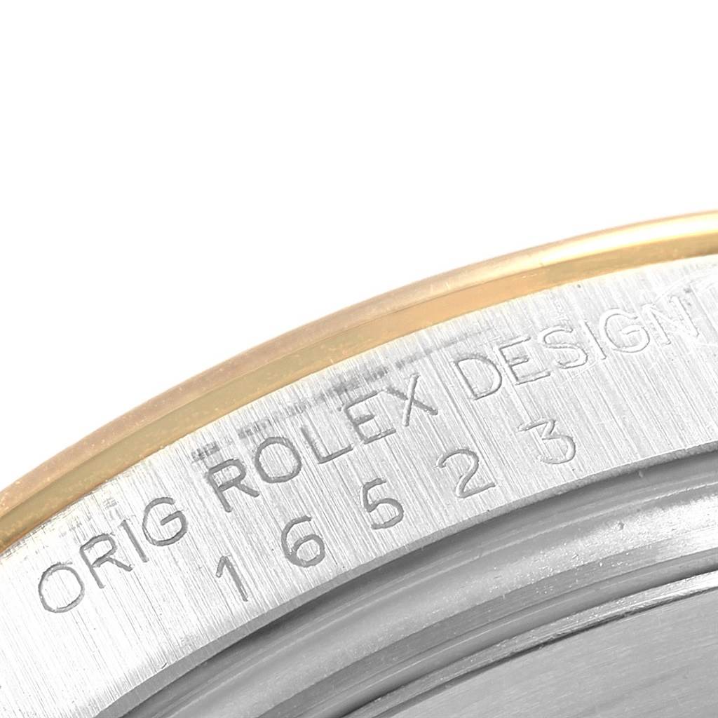 This image shows a close-up of the outer rim of a Rolex Daytona 16523 Men's Steel and Gold (two tone) Black Dial 16523 Men's Steel and Gold (two tone) Black Dial watch, highlighting the engraved model number and "Rolex Design" text.