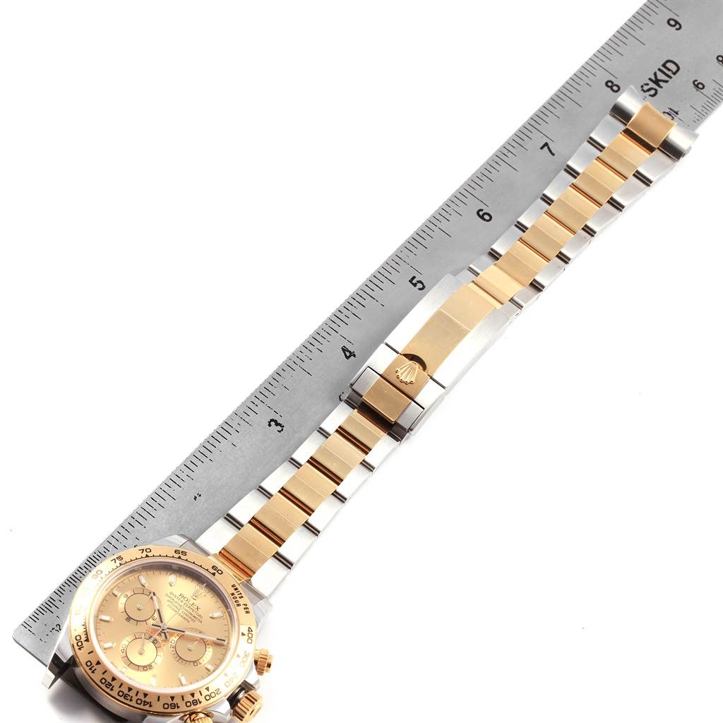 This image shows a top view of the Rolex Daytona 116503 Men's Steel and Gold (two tone) Champagne Dial 116503 Men's Steel and Gold (two tone) Champagne Dial watch, highlighting the dial, bezel, and metal bracelet next to a ruler.