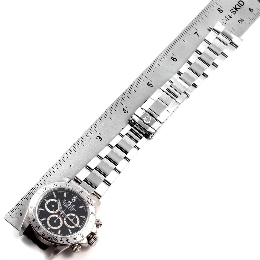 The image shows a Rolex Daytona 16520 Men's Stainless Steel Black Dial 16520 Men's Stainless Steel Black Dial watch laid flat with its bracelet measured against a ruler.