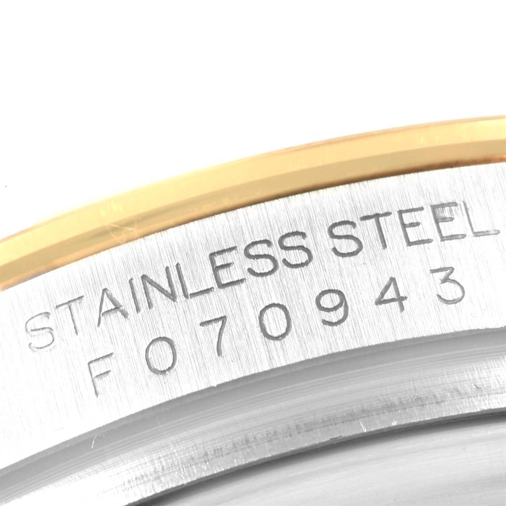 This close-up image shows a portion of the case back of a Rolex Daytona 116523 Men's Steel and Gold (two tone) Grey Dial 116523 Men's Steel and Gold (two tone) Grey Dial watch, highlighting its serial number and "STAINLESS STEEL" engraving.