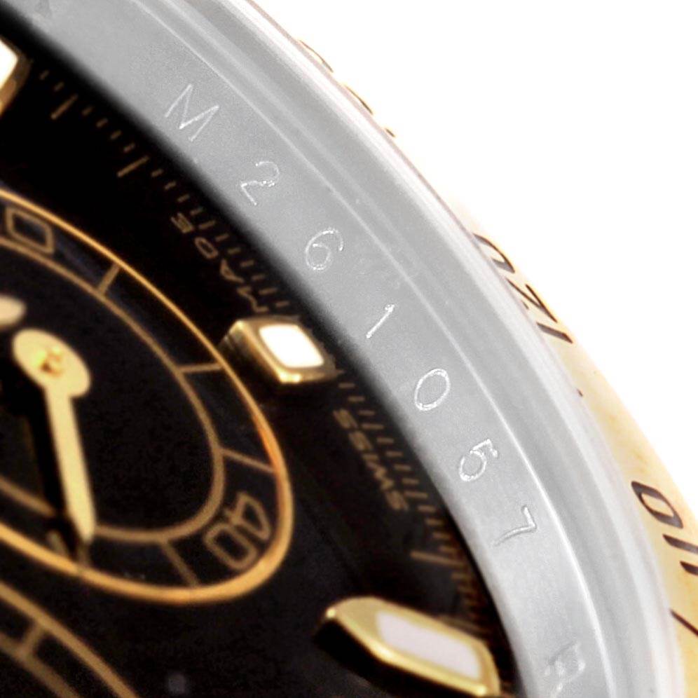 This close-up image shows the dial and bezel of a Rolex Daytona 116523 Men's Steel and Gold (two tone) Black Dial 116523 Men's Steel and Gold (two tone) Black Dial watch, highlighting the model's serial number.