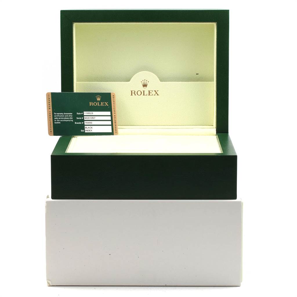 The image shows an open green and cream Rolex watch box for the Daytona model, with its warranty card displayed.