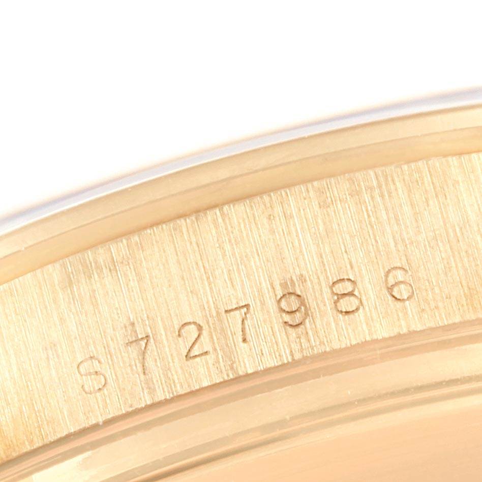 This close-up image shows the engraved serial number of a Rolex Daytona 16528 Men's Yellow Gold Black Dial 16528 Men's Yellow Gold Black Dial watch.