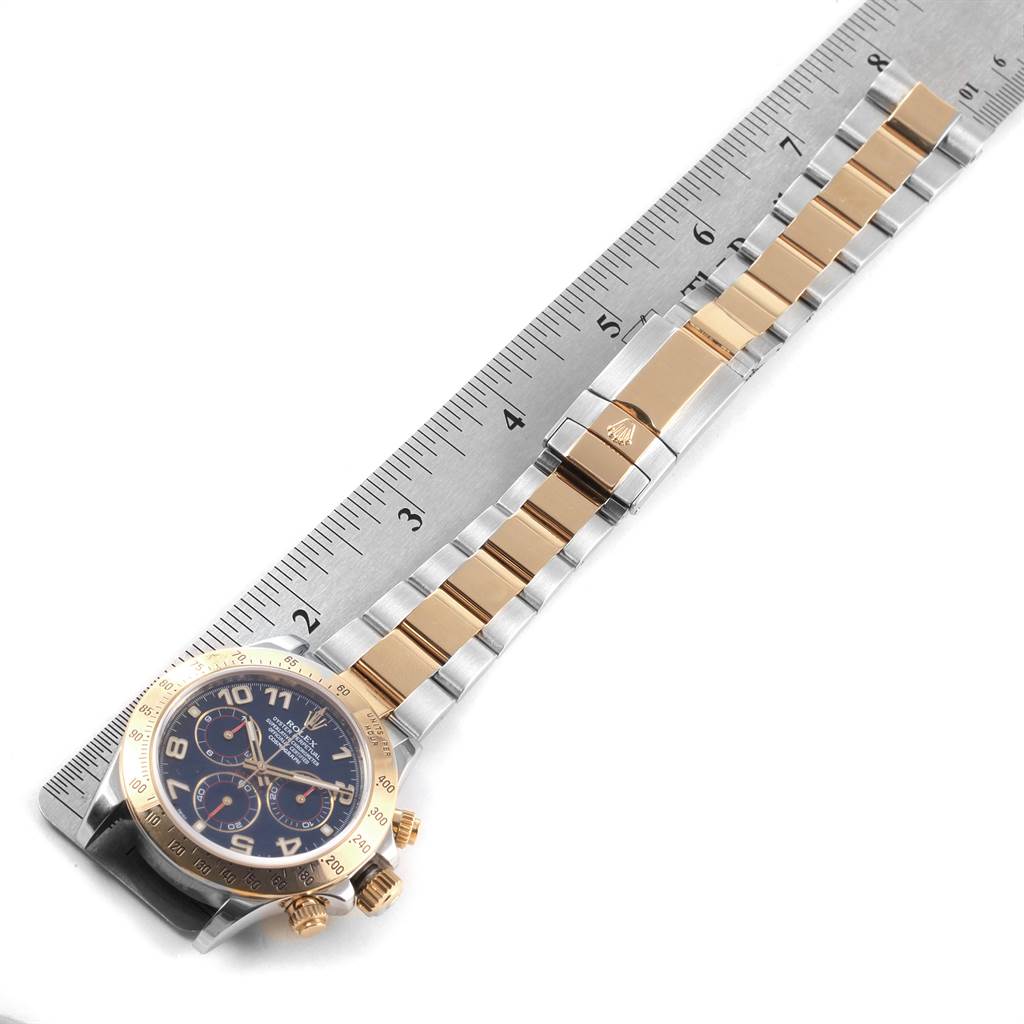 The Rolex Daytona 116523 Men's Steel and Gold (two tone) Blue Dial 116523 Men's Steel and Gold (two tone) Blue Dial watch is shown from a top-down angle, displaying the face, bezel, and band of the watch.