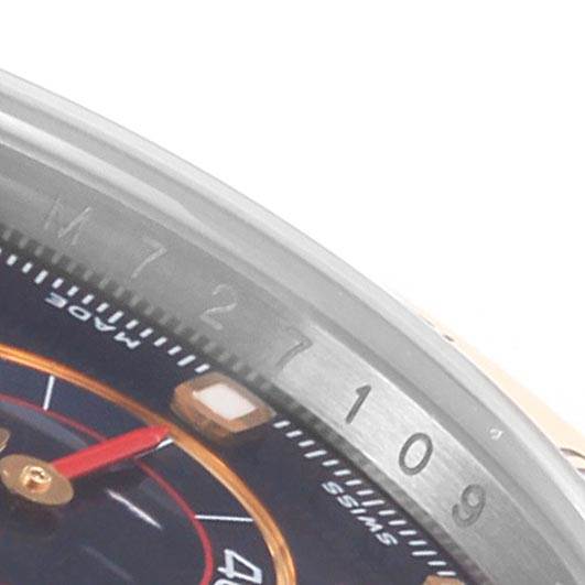 This is a close-up shot of the upper right side of the Rolex Daytona 116523 Men's Steel and Gold (two tone) Blue Dial 116523 Men's Steel and Gold (two tone) Blue Dial watch, showing part of the bezel and face.