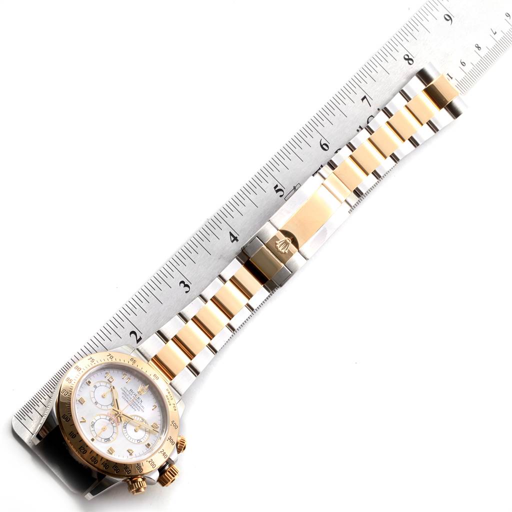This image shows the face and full bracelet of a Rolex Daytona 116523 Men's Steel and Gold (two tone) Mother of Pearl Dial 116523 Men's Steel and Gold (two tone) Mother of Pearl Dial watch with a ruler for scale.