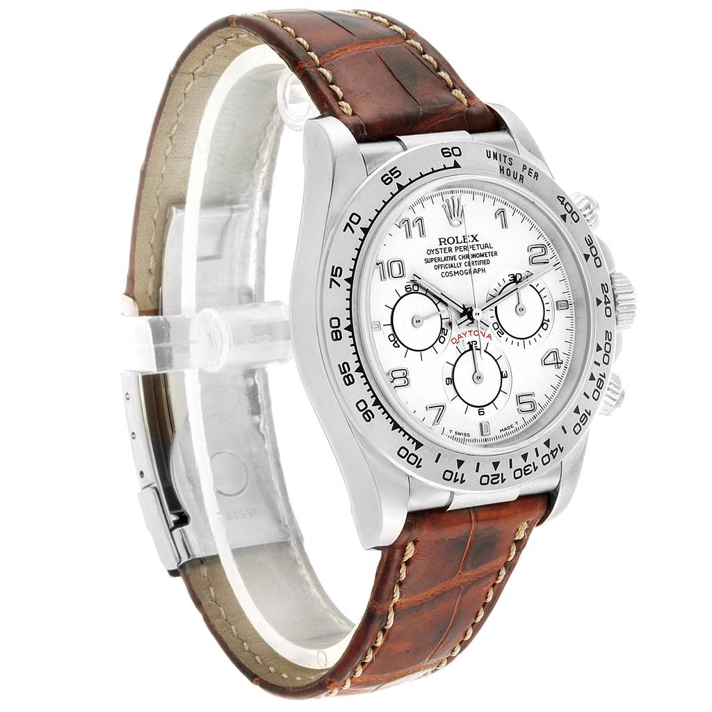 The image shows a Rolex Daytona 16519 Men
s White Gold White Dial 16519 Men
s White Gold White Dial watch at a three-quarter angle, highlighting its face, bezel, chronograph dials, and leather strap.