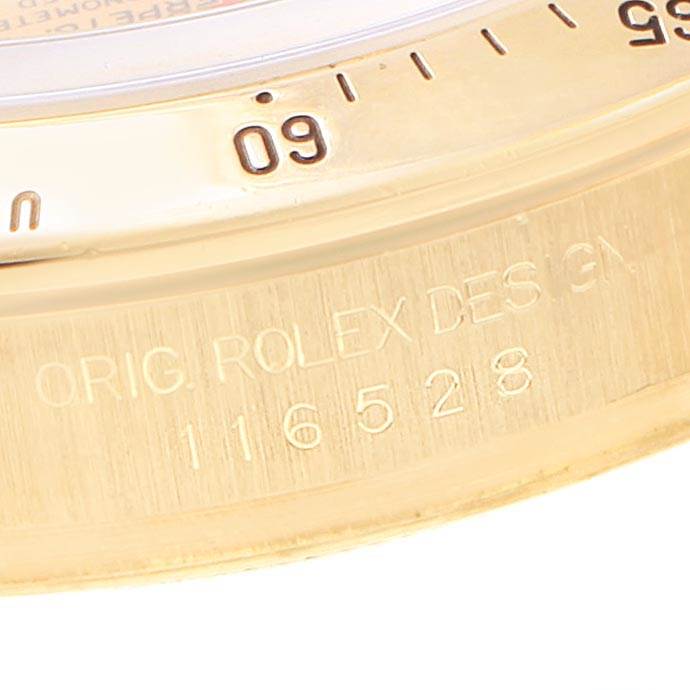 The image shows a close-up of the bezel and engraved case edge of a Rolex Daytona 116528 Men's Yellow Gold Champagne Dial 116528 Men's Yellow Gold Champagne Dial watch, highlighting the model number 116528.