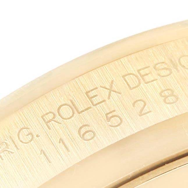 The image shows a close-up of the engraved side of the Rolex Daytona 116528 Men's Yellow Gold Black Dial 116528 Men's Yellow Gold Black Dial watch casing.
