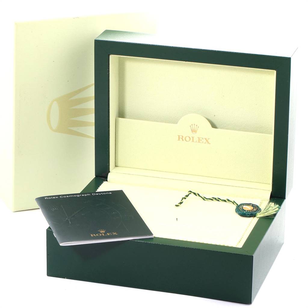 The image shows the official packaging for a Rolex Daytona 116528 Men's Yellow Gold Black Dial 116528 Men's Yellow Gold Black Dial, including the watch box, booklet, and tag.