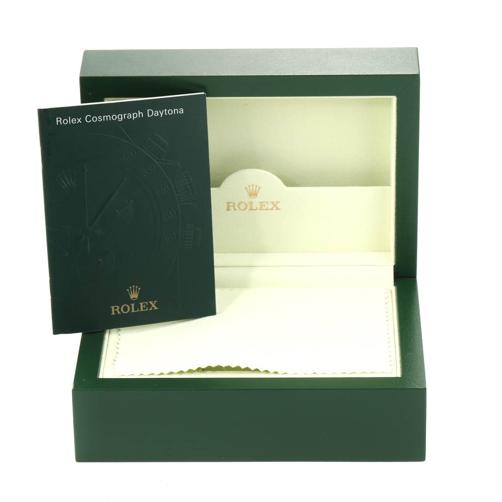 The image shows the open box of a Rolex Daytona 116520 Men's Stainless Steel Black Dial 116520 Men's Stainless Steel Black Dial watch along with its manual.