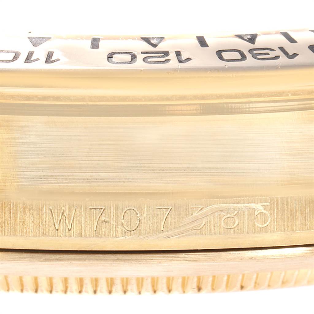 This close-up image shows the bezel and part of the caseback of a Rolex Daytona 16518 Men's Yellow Gold White Dial 16518 Men's Yellow Gold White Dial watch, including some engraved markings.