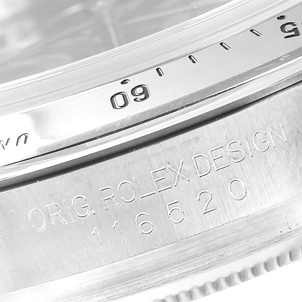 The image shows a close-up angle of the engraved model and serial numbers on the case of a Rolex Daytona 116520 Men's Stainless Steel Black Dial 116520 Men's Stainless Steel Black Dial watch.