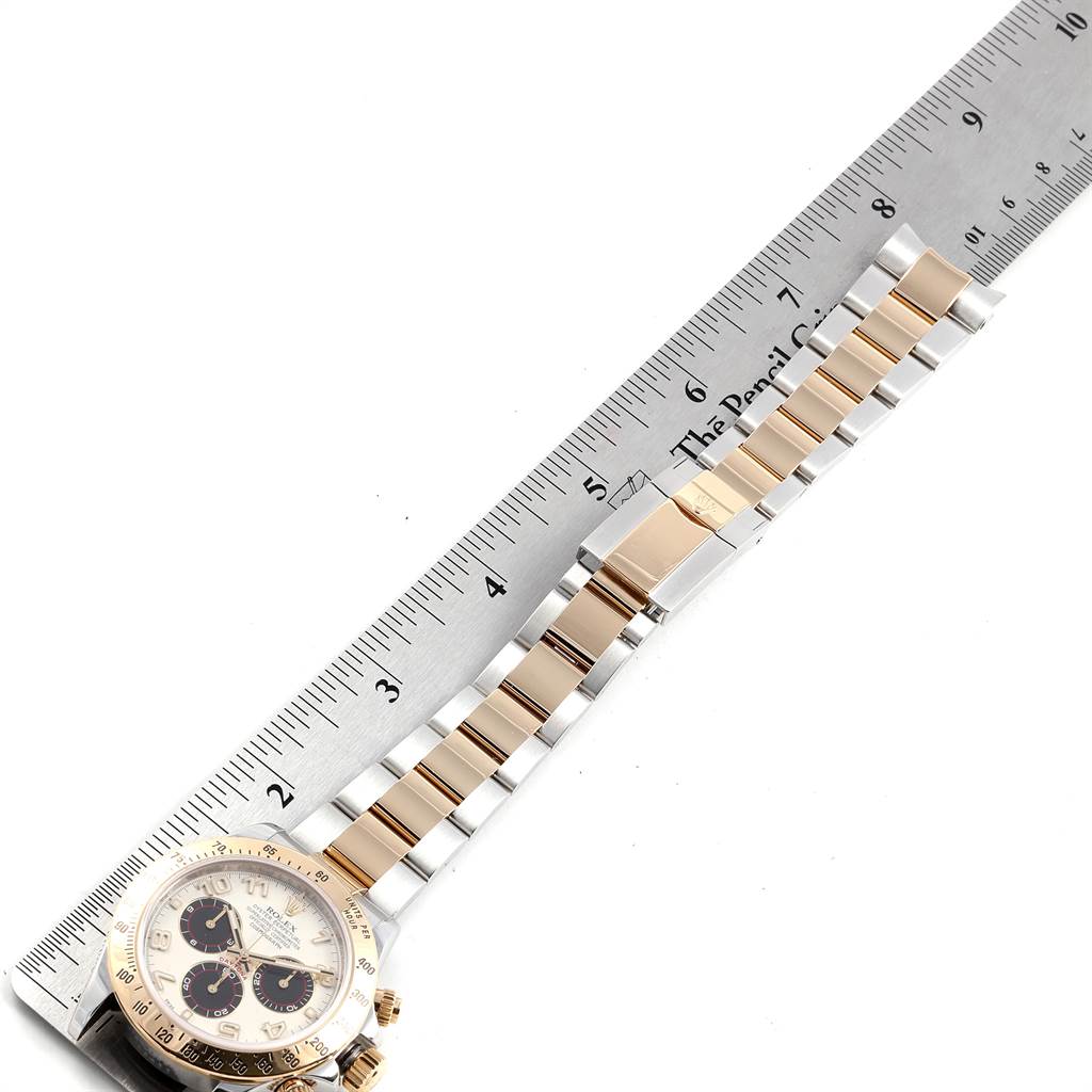 The image shows a side view of a Rolex Daytona 116523 Men's Steel and Gold (two tone) White Dial 116523 Men's Steel and Gold (two tone) White Dial watch with its bracelet laid out next to a ruler for measurement.