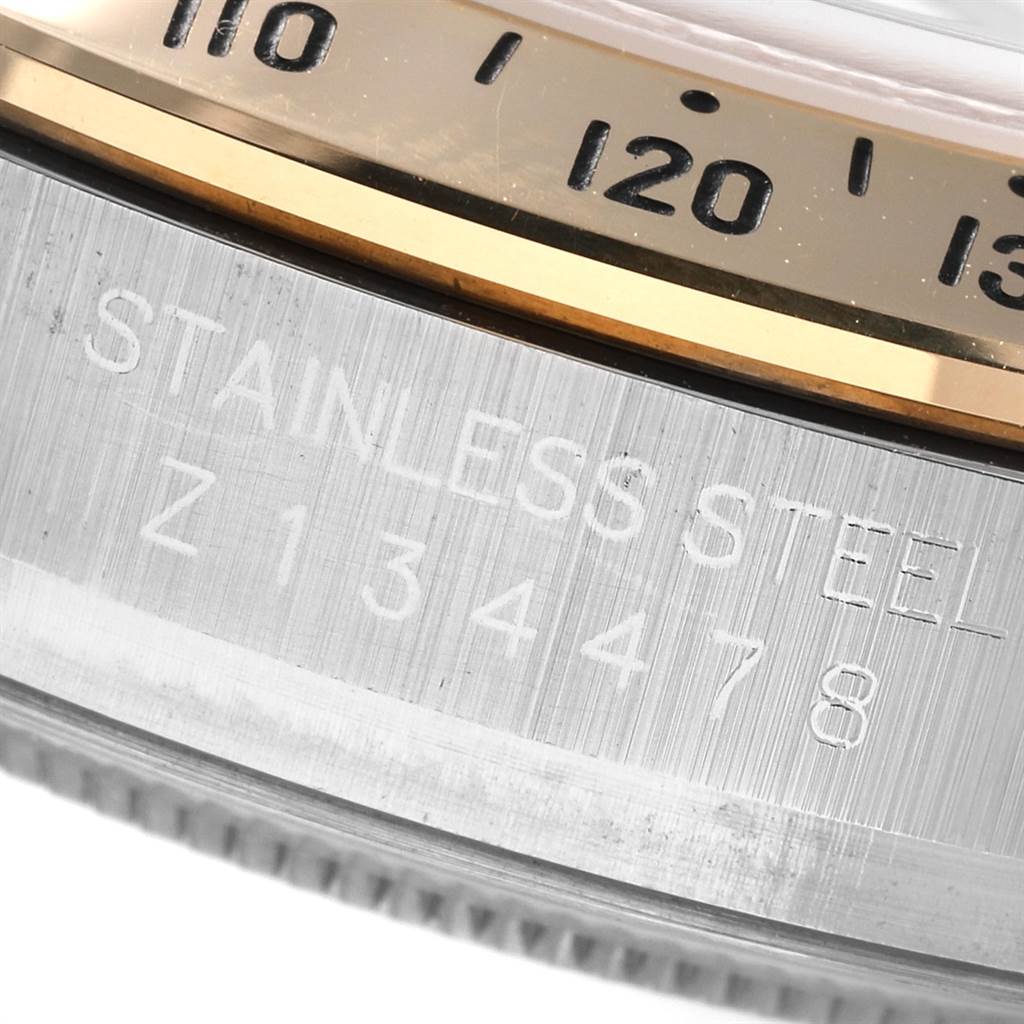 This close-up image shows the engraved stainless steel casing and part of the bezel of a Rolex Daytona 116523 Men's Steel and Gold (two tone) White Dial 116523 Men's Steel and Gold (two tone) White Dial watch.